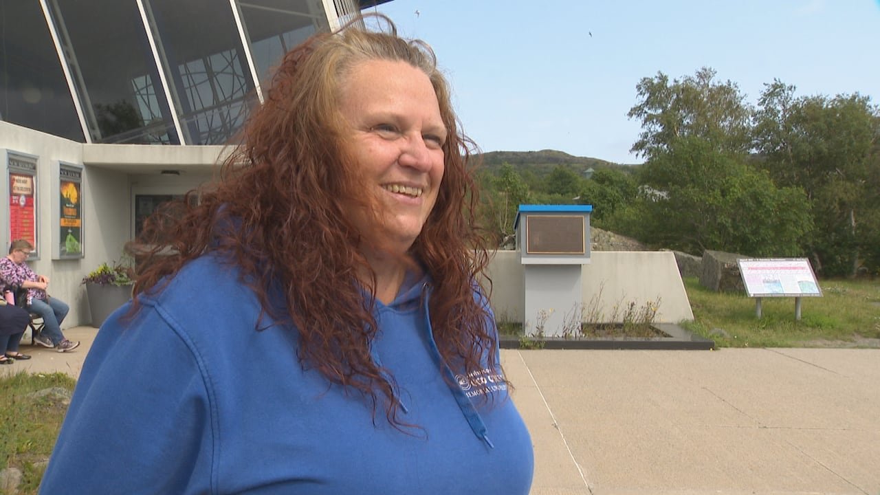 Woman with brown hair wearing a blue shirt.